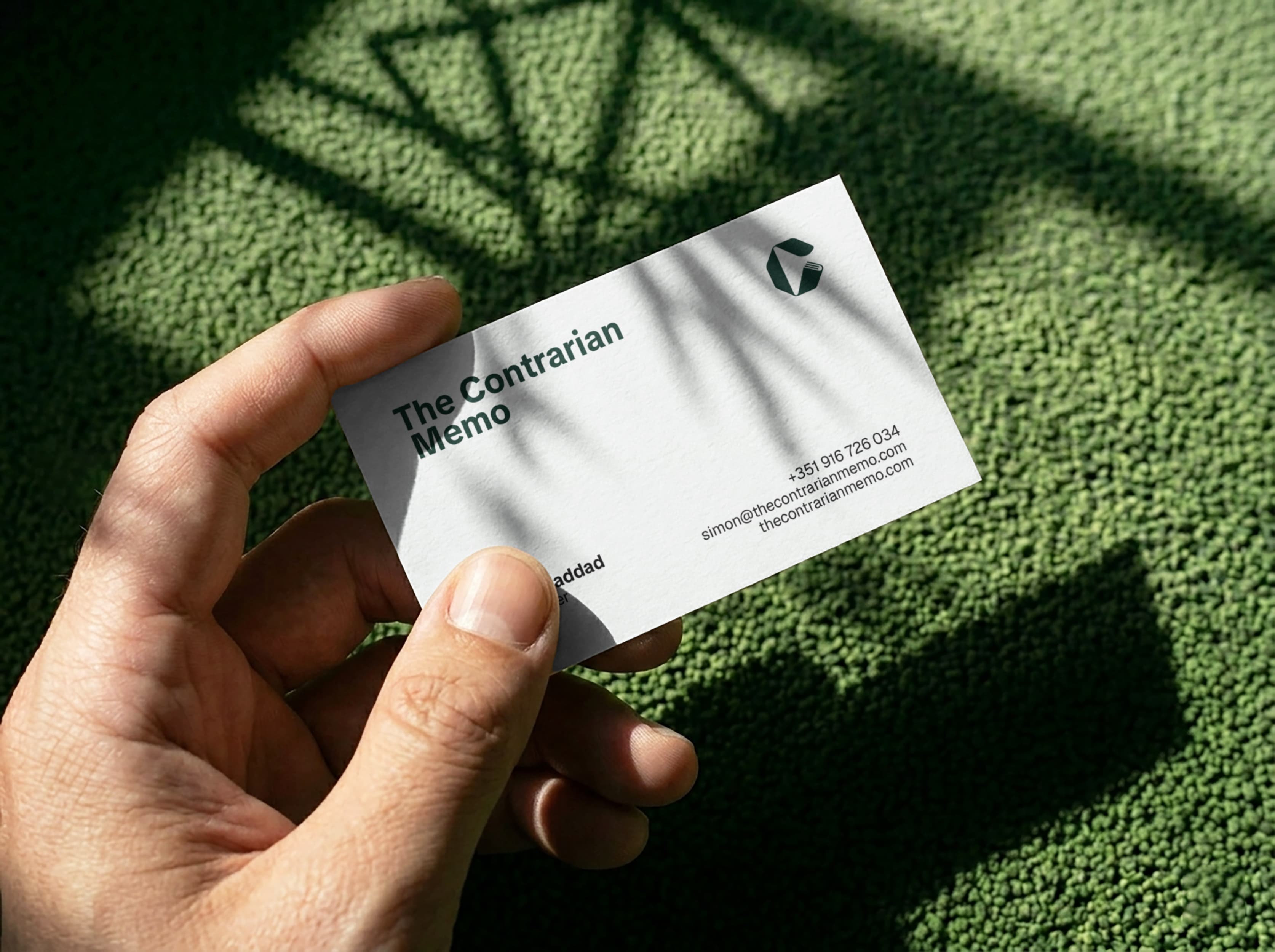 The Contrarian Memo business card held in hand
